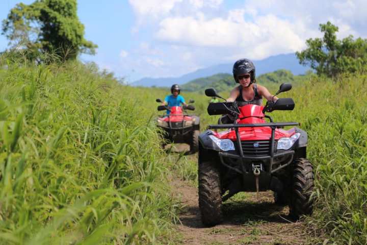 a man riding a motorcycle down a dirt road